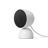Small, white Google Home Mini smart home camera positioned on a table, designed for voice-activated assistance.