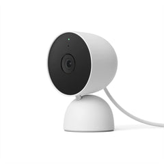 Small, white Google Home Mini smart home camera positioned on a table, designed for voice-activated assistance.