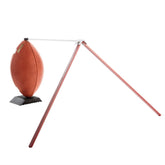 A football resting on a stand, held up by a red pole.