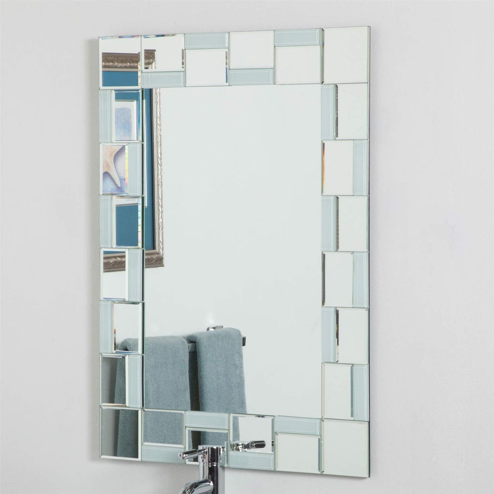 A bathroom mirror framed by square glass tiles, reflecting the surrounding space.