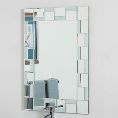 A bathroom mirror framed by square glass tiles, reflecting the surrounding space.