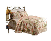 A cozy bed adorned with a vibrant floral comforter and decorative pillows.