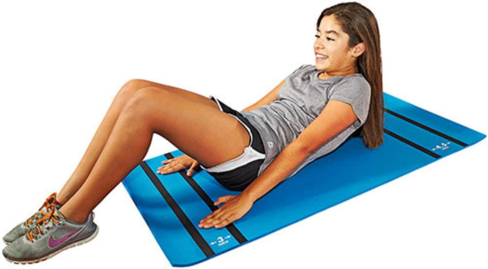 A woman is lying on a blue exercise mat, engaged in a fitness routine or relaxation.