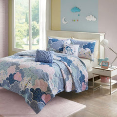A blue and pink comforter featuring a cloud pattern, adding a whimsical touch to a bedroom decor.