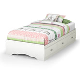 A white bed adorned with a colorful pink and green bedspread, creating a cheerful and inviting atmosphere.