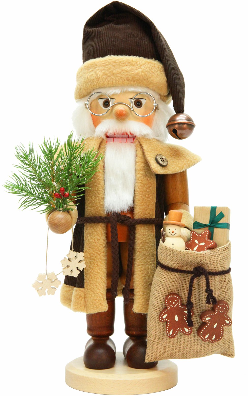 A nutcracker Santa Claus stands beside a decorated Christmas tree, holding a bag filled with gifts.