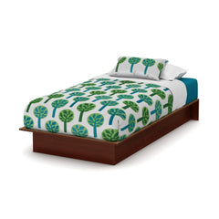 A bed adorned with a vibrant green and blue tree pattern, adding a fresh, natural touch to the room.