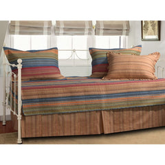 A striped day bed adorned with colorful pillows and a vibrant blanket, creating a cozy and inviting atmosphere.