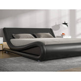 A stylish modern bed adorned with black leather furniture, emphasizing a sophisticated and elegant bedroom look.