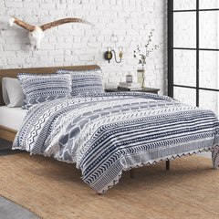 A blue and white comforter featuring a modern geometric pattern, neatly spread out on a bed.