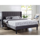 A well-made bed with a gray upholstered headboard, adding a touch of elegance to the room's decor.