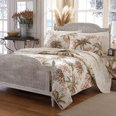 A cozy bed adorned with a white bedspread and a white headboard, creating a serene atmosphere.