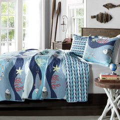 A blue and white bed designed with an ocean theme, complete with wave motifs and seaside decorations.