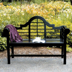 A bench covered with a vibrant purple blanket, inviting relaxation in a tranquil outdoor setting.