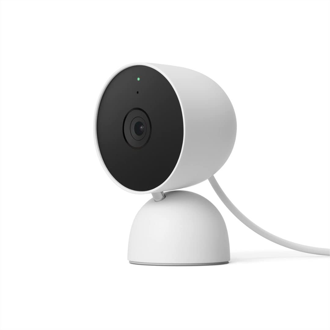 Small, white Google Home Mini smart home camera positioned on a table, designed for voice-activated assistance.