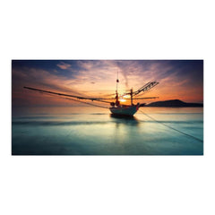 A fishing boat sails through the ocean at sunset, surrounded by hues of orange and pink illuminating the sky and water.