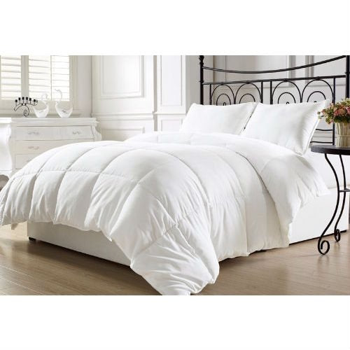 A white comforter on a black iron bed frame, showcasing a modern and elegant bedroom design.