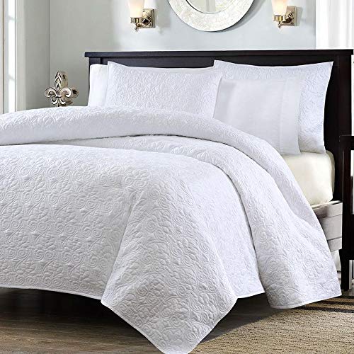 A soft white comforter laid out with a coordinating white pillow on top.