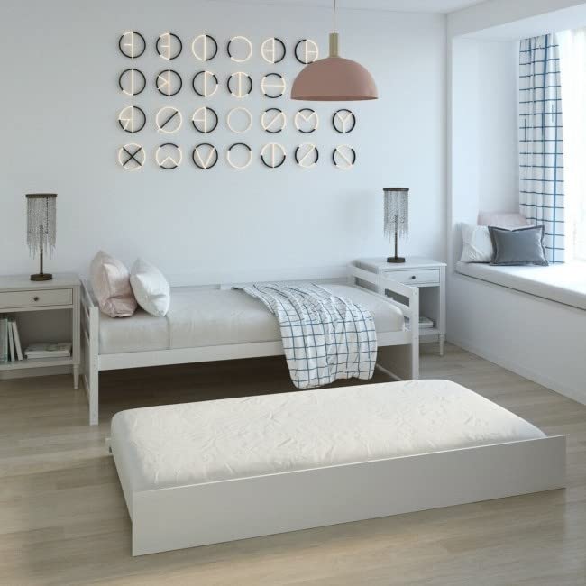 A minimalist bedroom featuring a white bed, white mattress, and a white nightstand, all in a cohesive color scheme.