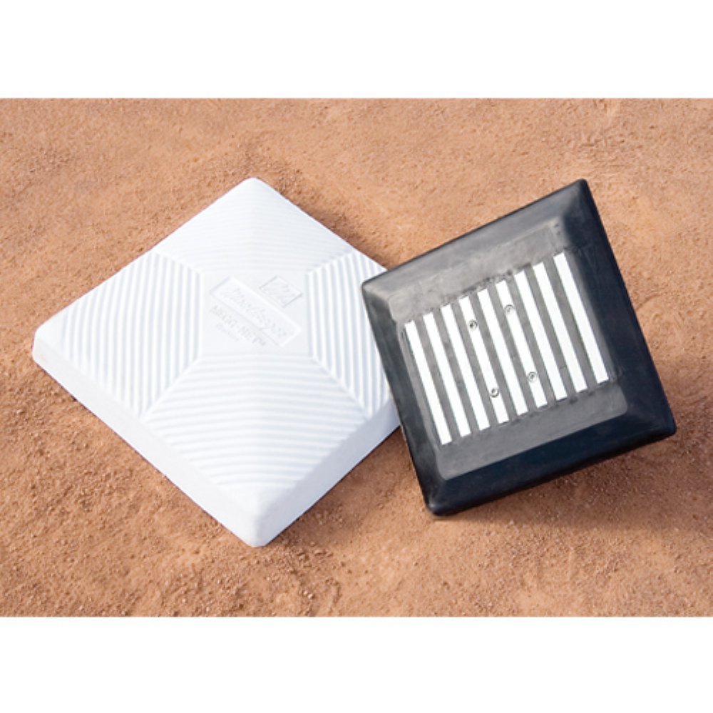 A baseball field with a distinct white and black square marking the center, set against a backdrop of lush green grass.