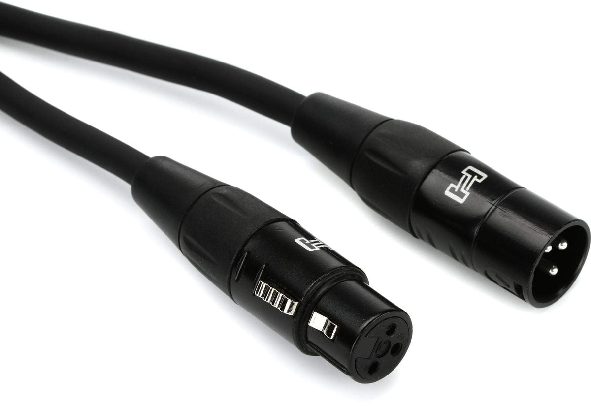 A pair of black and white cables with a black plug, coiled together on a neutral background.