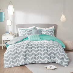 A gray and turquoise comforter set on a white bed, showcasing a modern and cozy bedding arrangement.