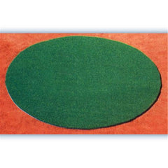 A green round rug placed on a vibrant red surface, creating a striking color contrast.