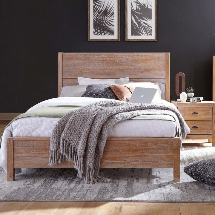 A cozy bedroom featuring a wooden bed flanked by matching nightstands, creating a warm and inviting atmosphere.