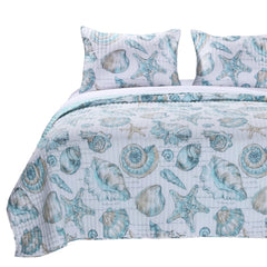 A bed set in blue and white adorned with shell designs, perfect for a beach-inspired decor.