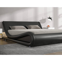 A stylish modern bed adorned with black leather furniture, emphasizing a sophisticated and elegant bedroom look.
