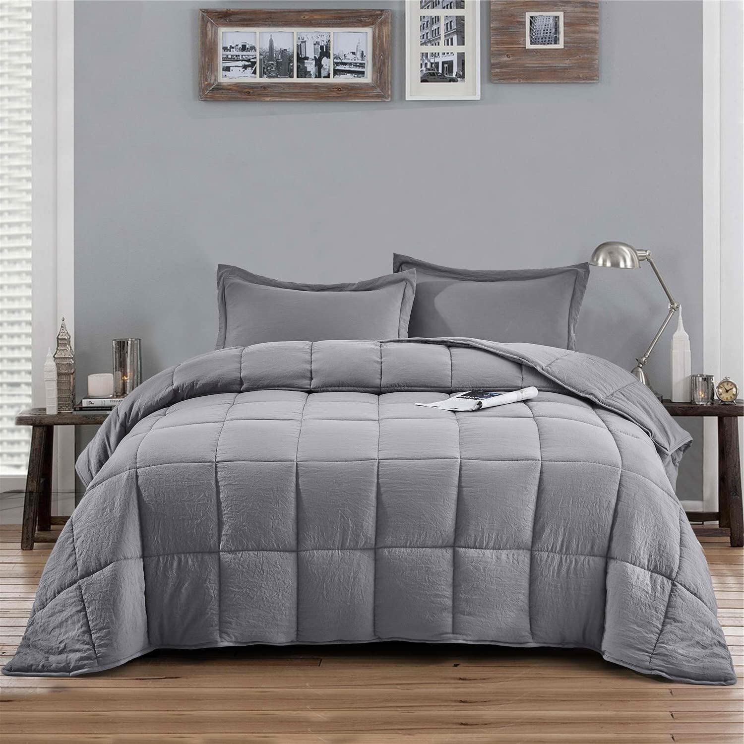 A gray comforter featuring a pillow placed on top, creating a cozy bed setting.