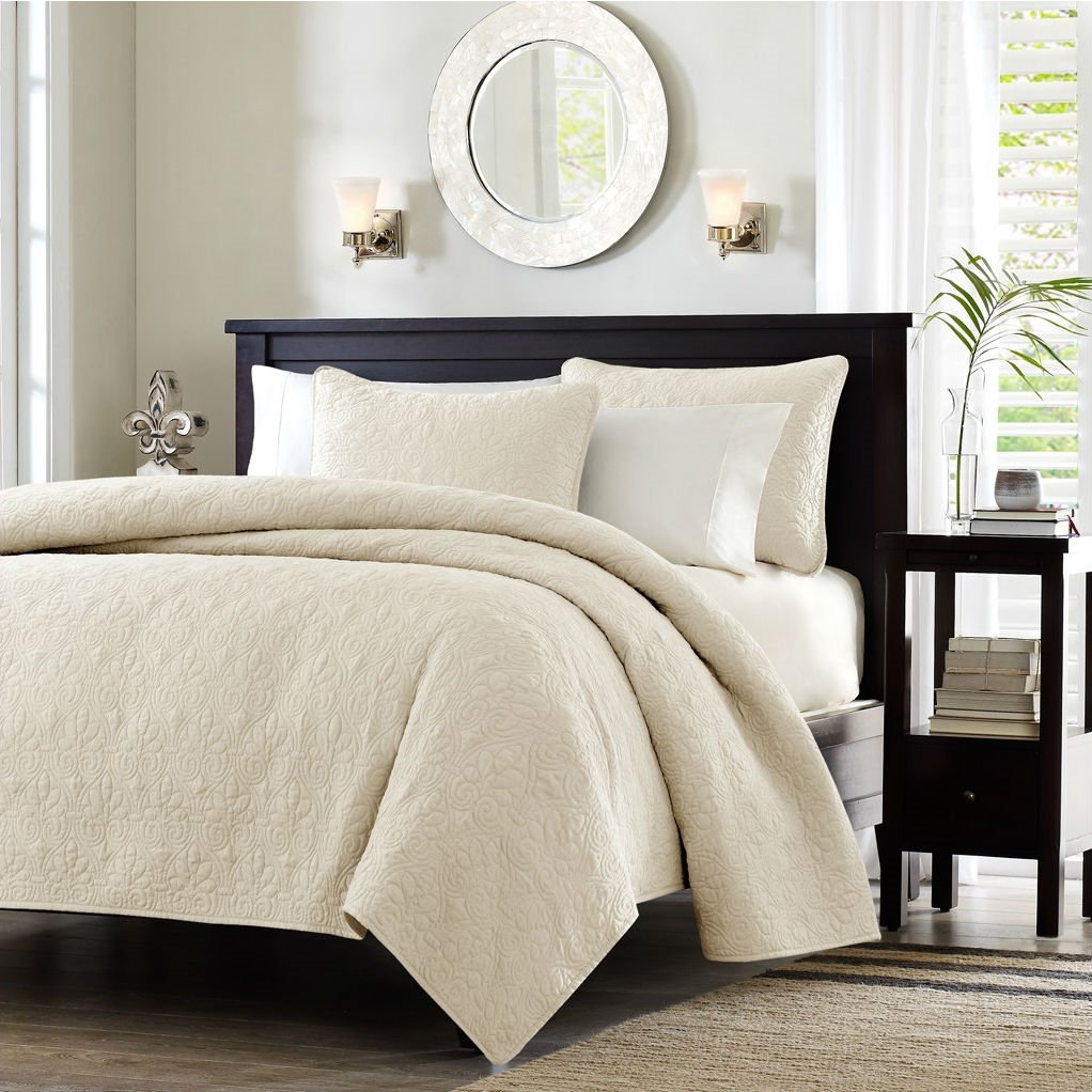 A stylish white bed with a black headboard and a white comforter, offering a clean and modern look in the bedroom.