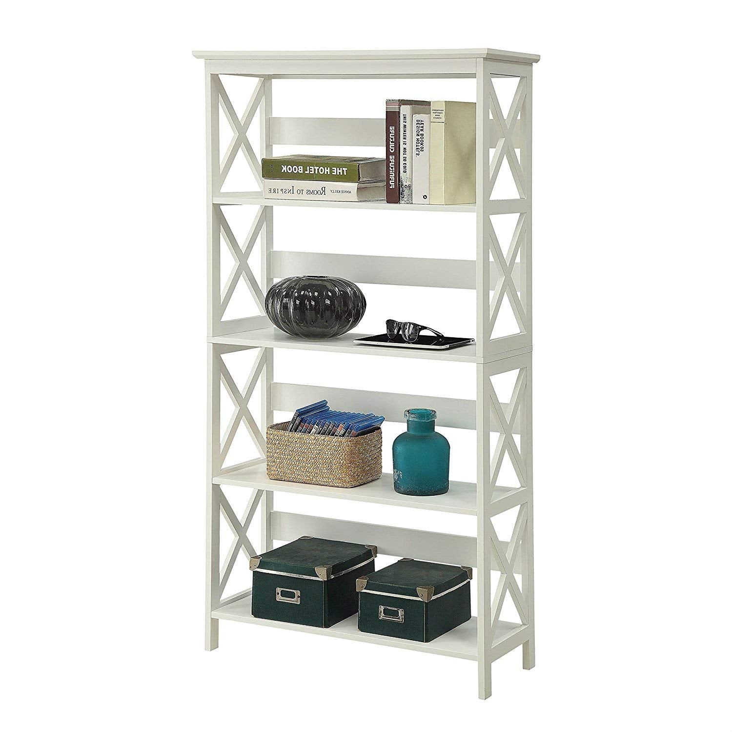 A white bookcase with three shelves, including a basket for storage on the bottom shelf.