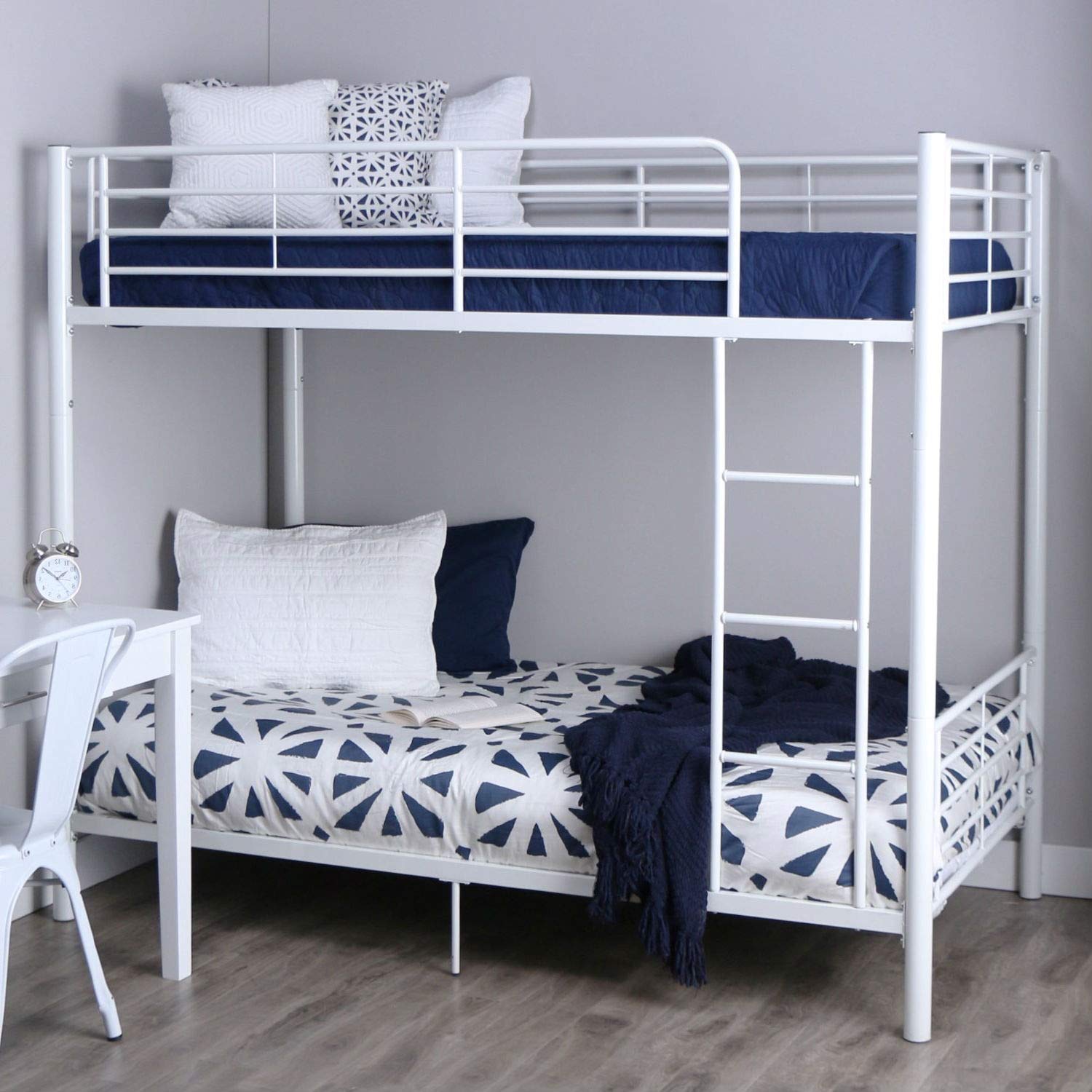 A white bunk bed featuring blue and white pillows, designed for a stylish and comfortable bedroom environment.