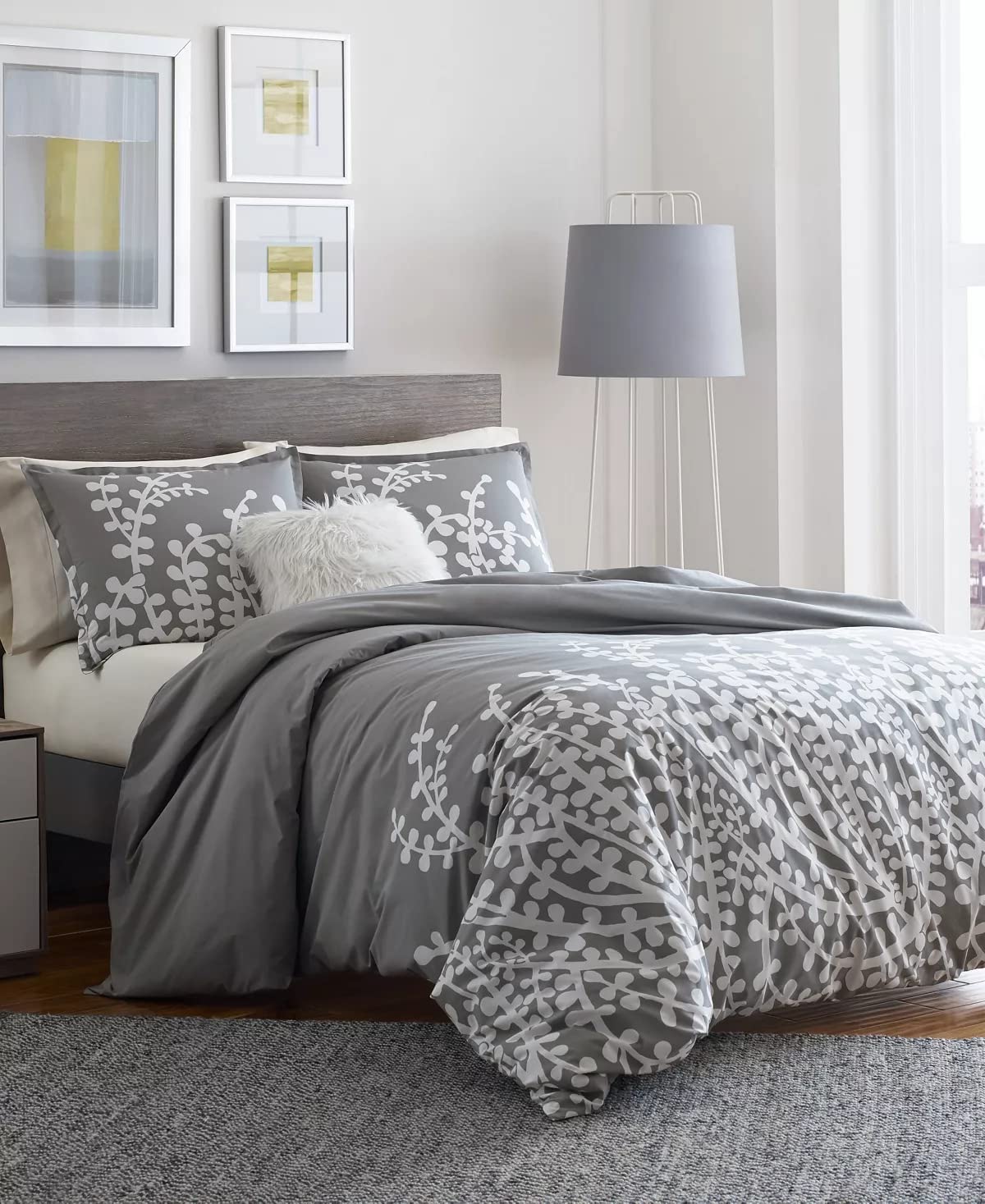 A gray and white bed featuring a soft gray comforter, neatly arranged for a cozy appearance.