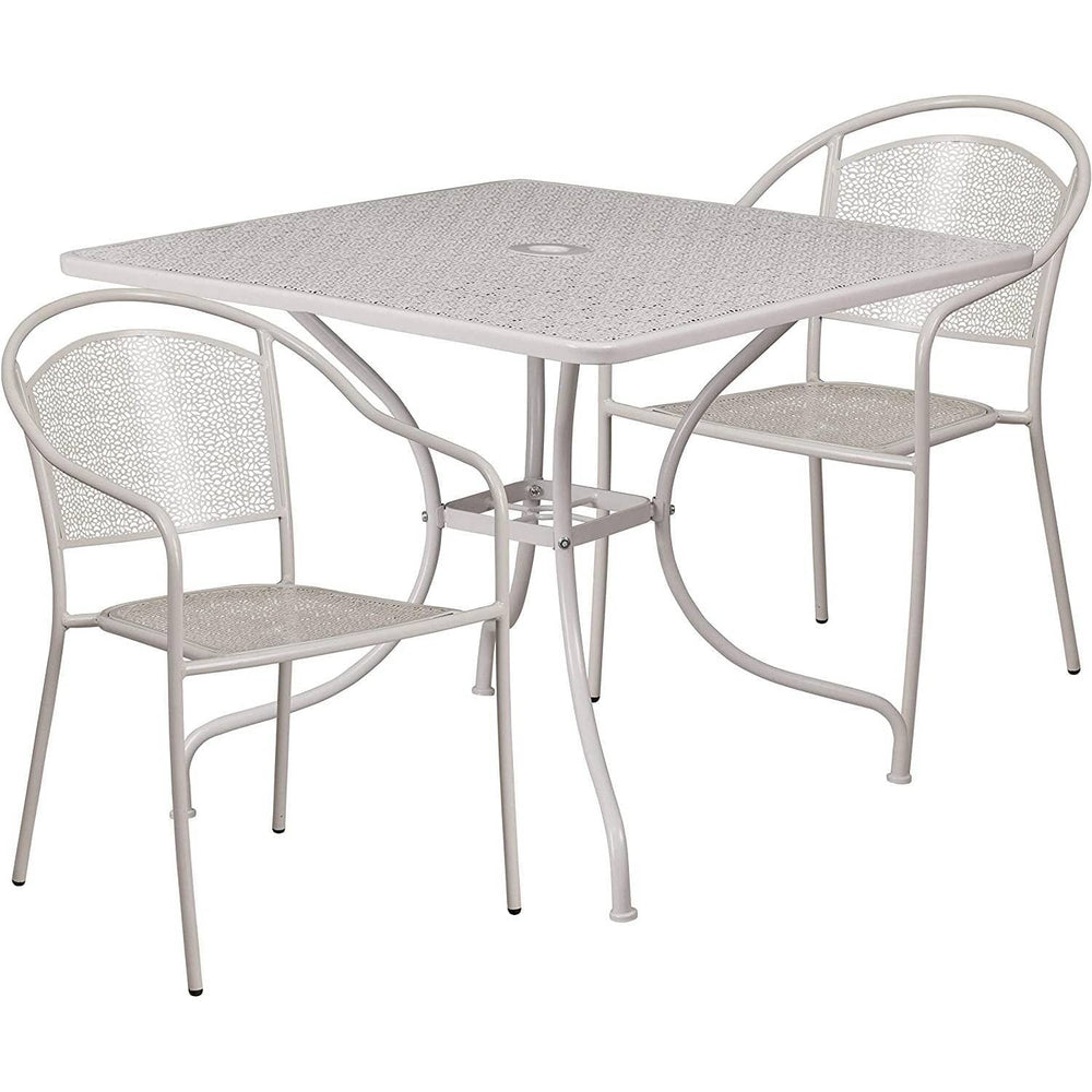 A white outdoor table accompanied by two matching chairs set against a natural background.