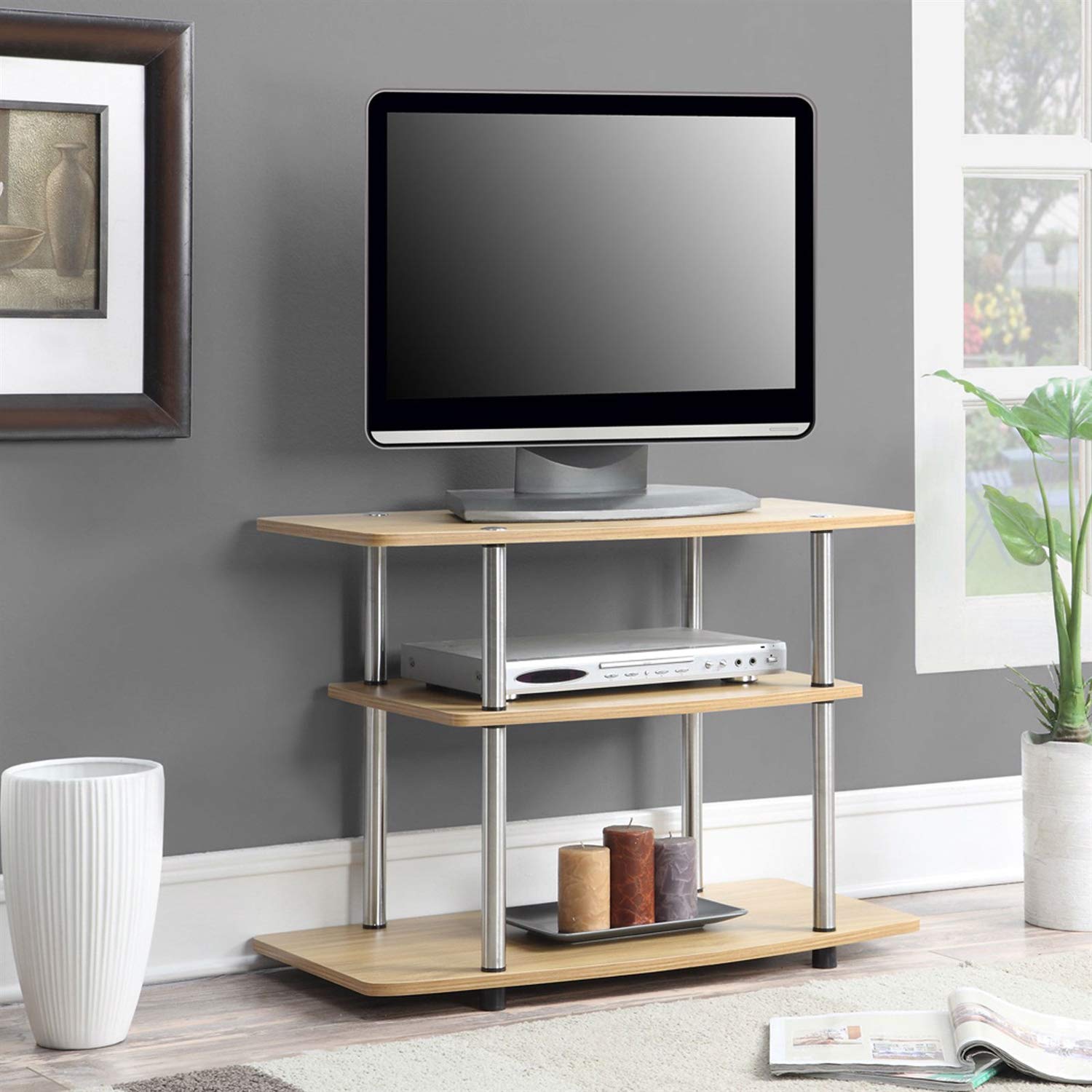 A sleek TV stand with a flat screen TV on top and a lower shelf for additional storage or decorative objects.