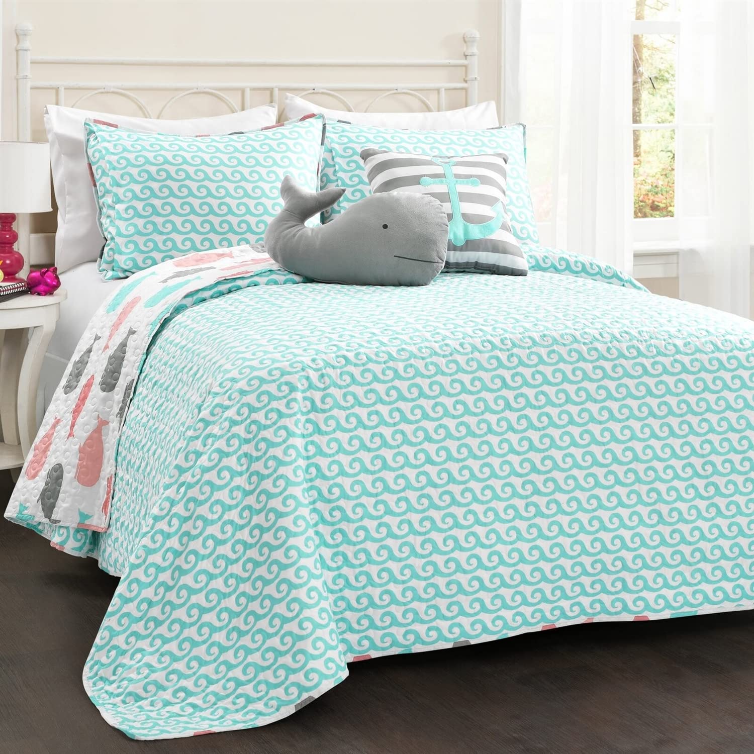 A neatly made bed adorned with a soft, oversized whale toy, adding a touch of charm to the bedroom decor.