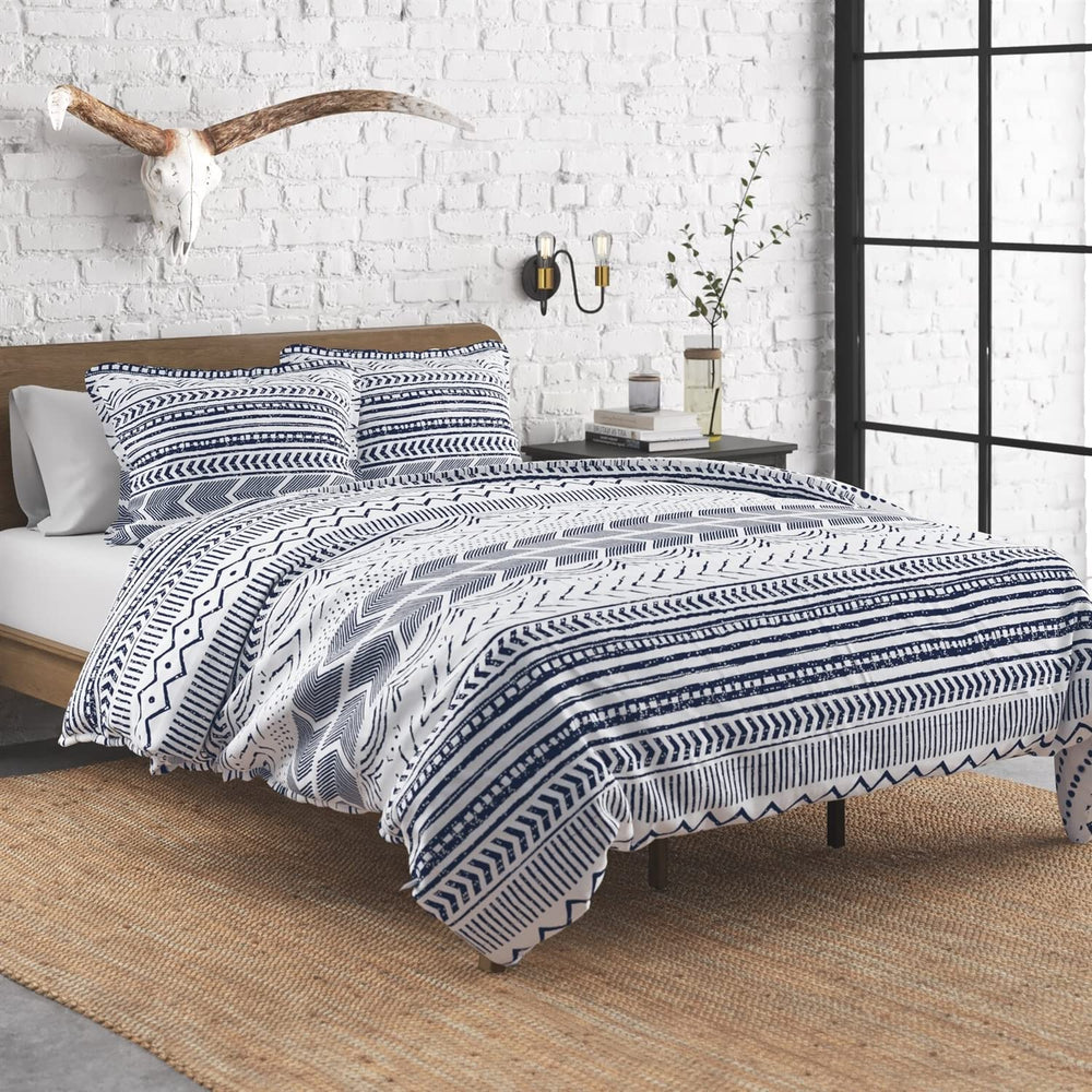 A blue and white comforter featuring a modern geometric pattern, neatly spread out on a bed.