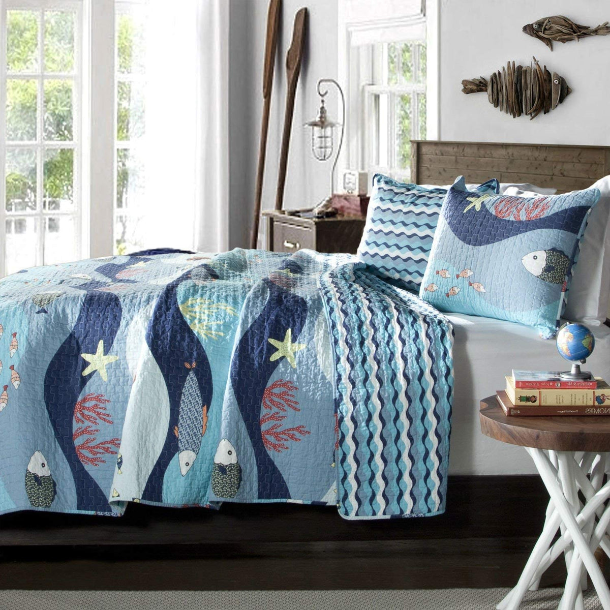 A blue and white bed designed with an ocean theme, complete with wave motifs and seaside decorations.