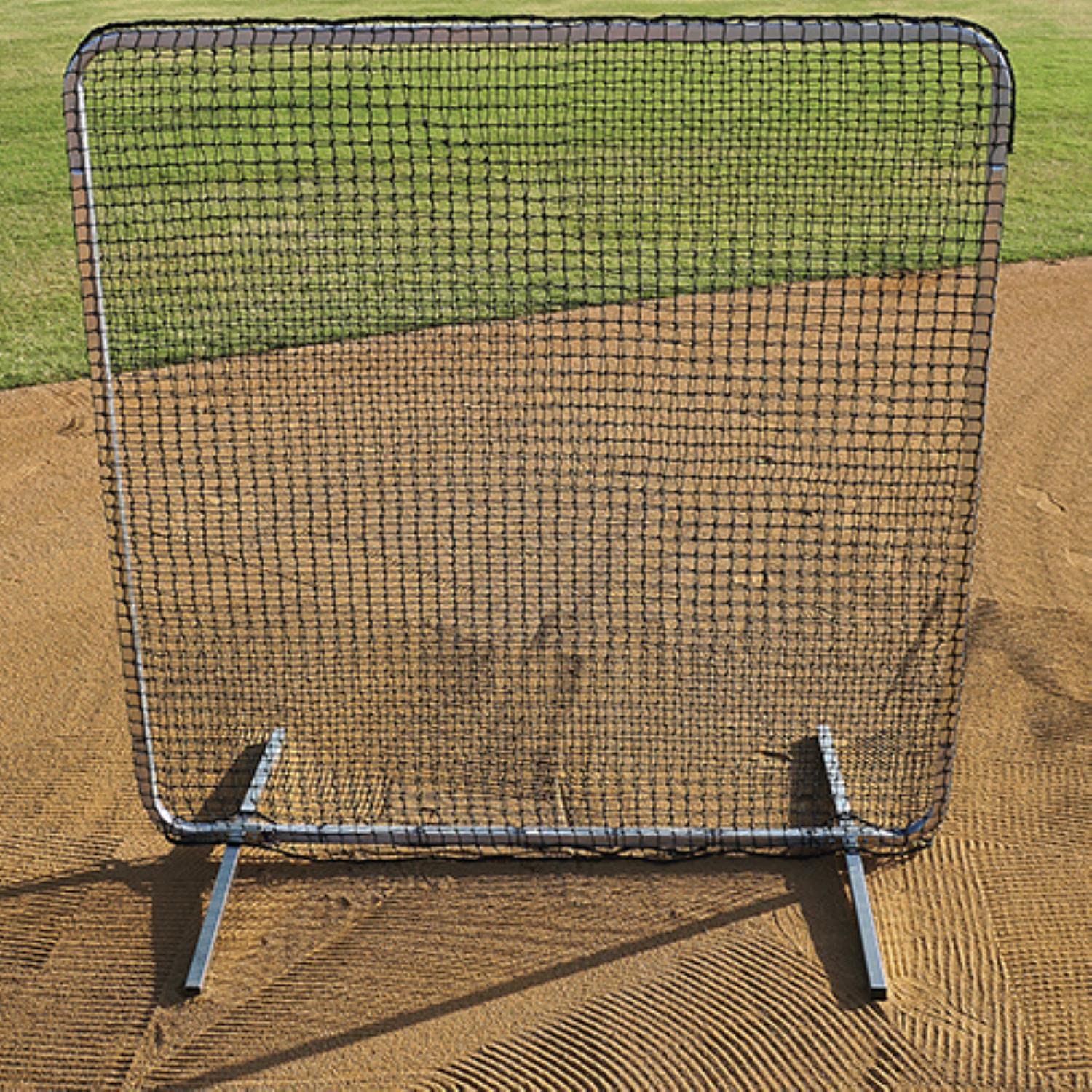 A baseball screen lying flat on the ground in a field, used for training or practice purposes.