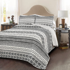 A stylish black and white bed adorned with a tribal print, blending contemporary design with cultural elements.
