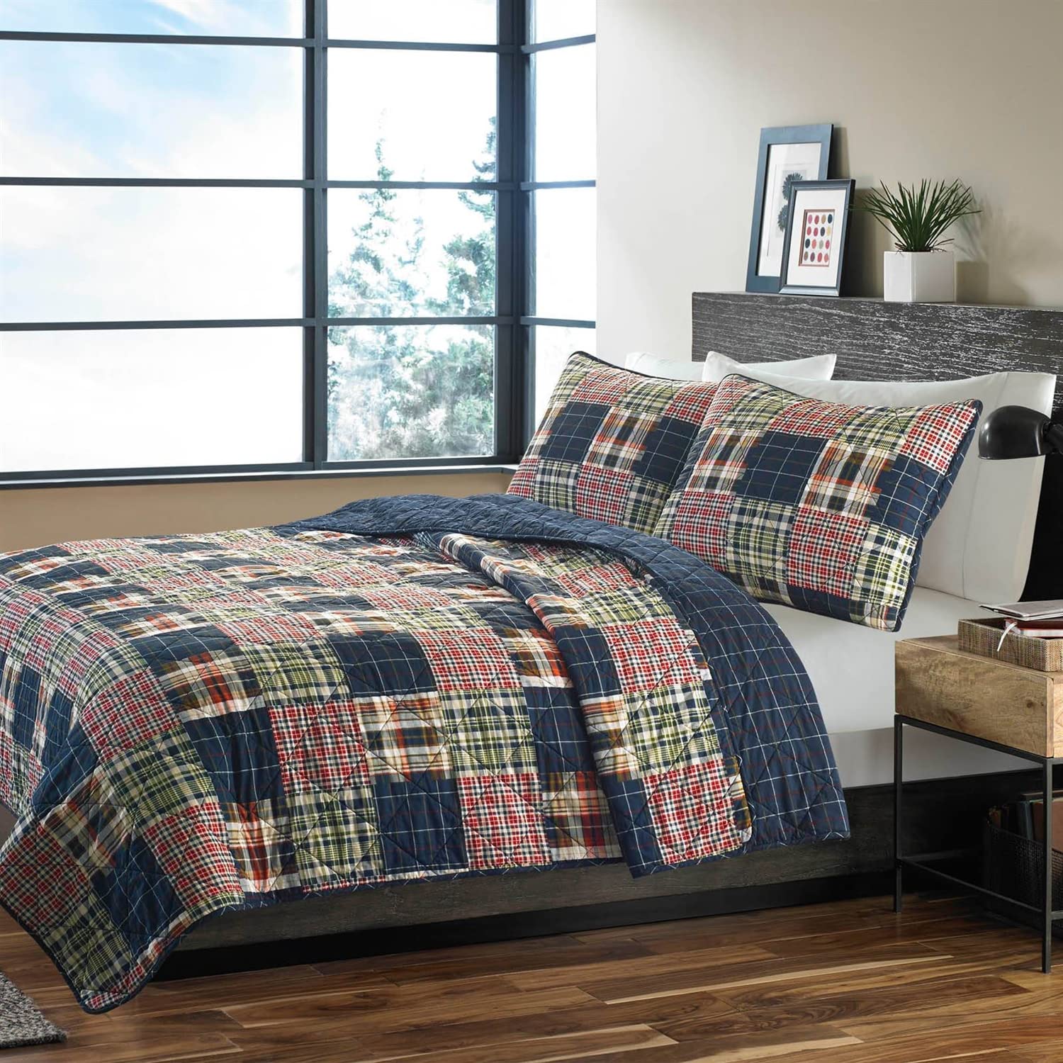 A stylish bed with a plaid quilt and an assortment of pillows for added comfort.