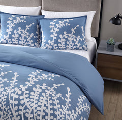 A blue comforter featuring delicate white flowers, adding a touch of elegance to the bedding.