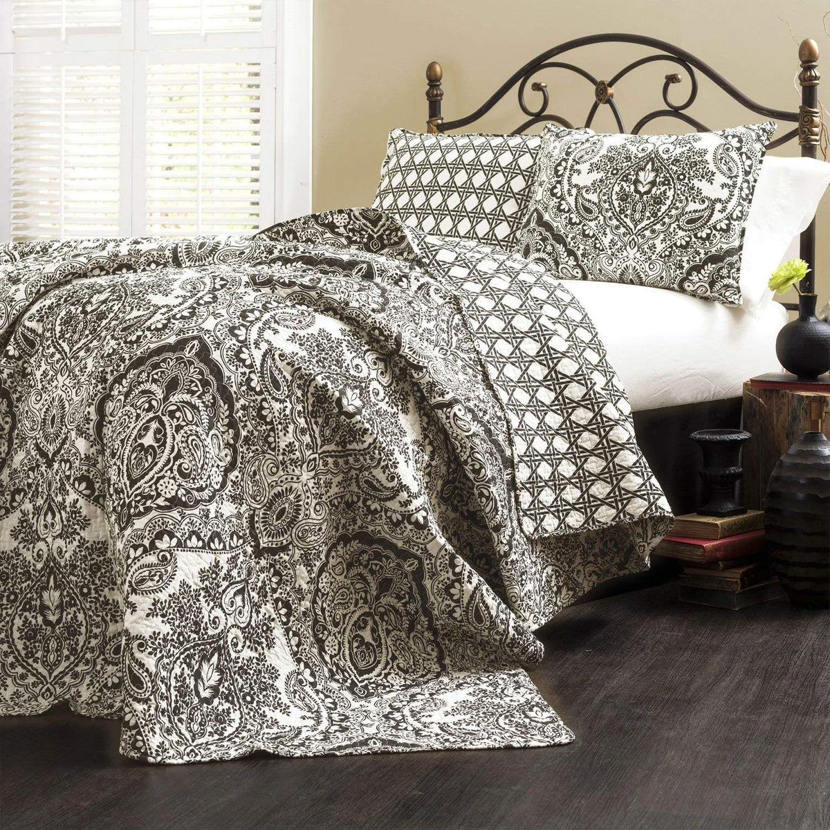  A bed adorned with a black and white paisley print, showcasing intricate patterns on the bedding.